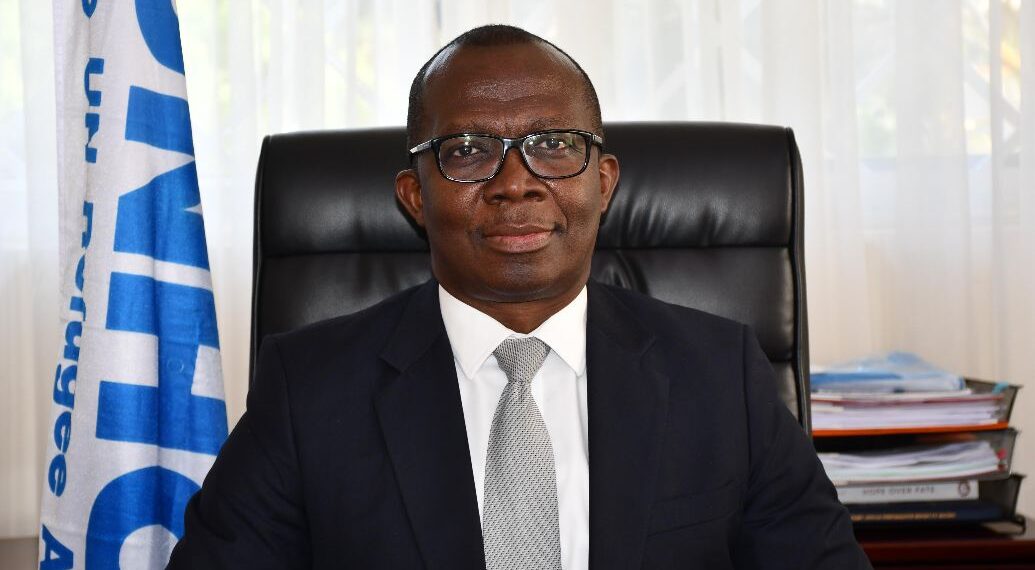 Matthew Kwesi Crentsil, Ghanaian humanitarian leader and UNHCR veteran, seated at his office desk.