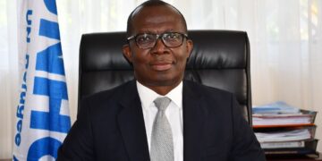 Matthew Kwesi Crentsil, Ghanaian humanitarian leader and UNHCR veteran, seated at his office desk.