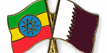 Crossed flags of Ethiopia and Qatar symbolising diplomatic and economic partnership.