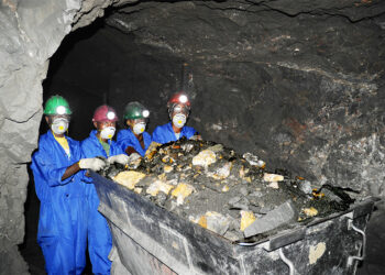 Miners wearing protective gear work underground in Cote d’Ivoire, extracting mineral-rich ore during exploration for lithium and other critical minerals.
