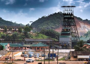 Bogoso-Prestea gold mine in Ghana, showing mining infrastructure and surrounding hills under cloudy skies.