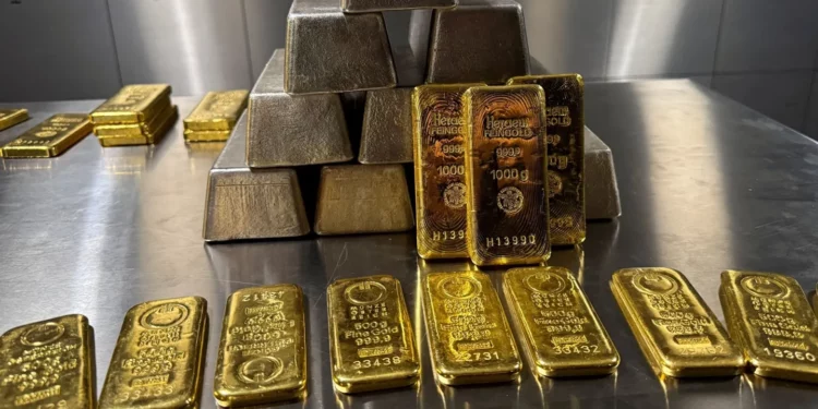 Stacks of refined gold bars on a metal surface, representing the UAE’s rising gold imports from Sudan in 2024.