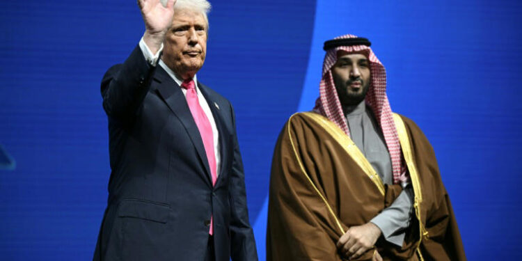 US President Donald Trump waves while standing beside Saudi Crown Prince Mohammed bin Salman during an event