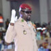 General Mamady Doumbouya raises his right hand during a swearing-in ceremony in Conakry, wearing a military uniform and red beret.
