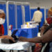 A health worker speaks with a mother and child at a public clinic in Eswatini, highlighting ongoing challenges in the country’s healthcare system.