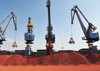 Cargo cranes loading bauxite at a port in Guinea-Conakry, highlighting the country’s growing export capacity and infrastructure development.
