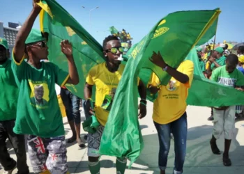 Supporters of Tanzania’s ruling party wave flags during an election rally in Dar es Salaam.