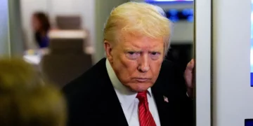 Donald Trump looks on during a media interaction aboard his campaign aircraft.