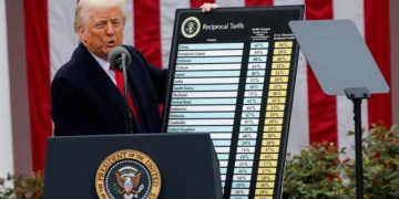 Donald Trump stands at a podium in the White House Rose Garden holding a large chart labelled ‘Reciprocal Tariffs’, listing tariff rates for multiple countries.
