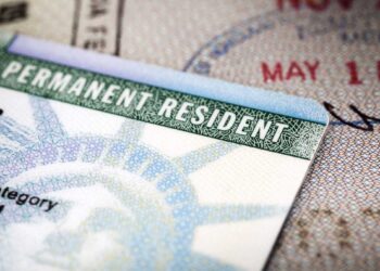 Close-up image of a US permanent resident green card placed on a passport