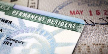 Close-up image of a US permanent resident green card placed on a passport