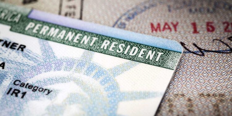 Close-up image of a US permanent resident green card placed on a passport