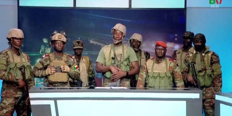 A group of Beninese soldiers in uniform read a statement on national television during a brief attempted coup in Cotonou