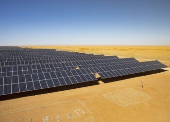Large aerial view of the Cazombo solar farm in Angola, showing extensive solar panels and battery storage units in a rural landscape