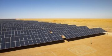 Large aerial view of the Cazombo solar farm in Angola, showing extensive solar panels and battery storage units in a rural landscape