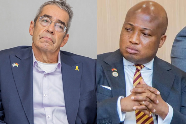 A Ghanaian government official and an Israeli diplomat sit side by side during a meeting, both appearing serious.