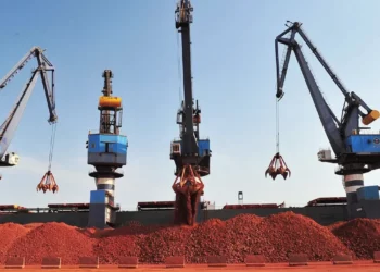 Bauxite ore being loaded by cranes at a port facility in Guinea, the world’s largest bauxite producer