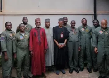 Nigeria’s Foreign Minister Yusuf Tuggar standing with Nigerian military servicemen in flight uniforms following their release after detention in Burkina Faso.
