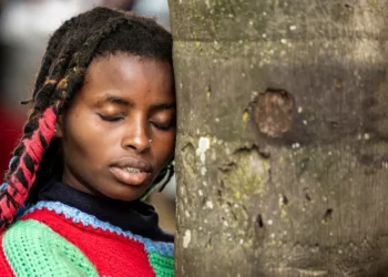 Truphena Muthoni rests against a tree while attempting her 72-hour tree-hug record in Nyeri, Kenya