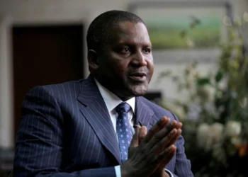 Aliko Dangote speaking during an interview, wearing a dark pinstripe suit