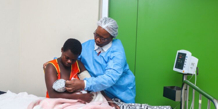 Healthcare worker checks blood pressure of a young patient in a public hospital ward in Eswatini, highlighting frontline care and health system capacity