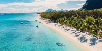 Aerial view of Mauritius coastline with white-sand beach, turquoise Indian Ocean waters and palm-lined shore