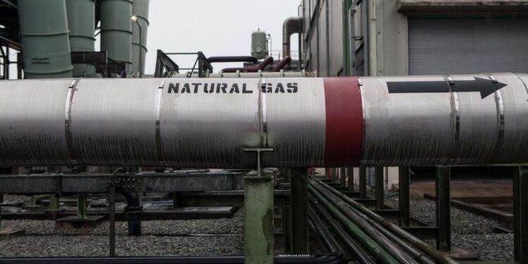 Natural gas pipeline at an industrial facility, showing flow direction towards processing units in Africa