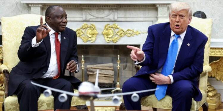 South African President Cyril Ramaphosa and US President Donald Trump talking during a meeting in the Oval Office, seated facing each other with a model aircraft in the foreground