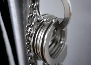 Handcuffs hanging from metal bars, symbolising arrests linked to Ethiopia’s $13m human trafficking investigation