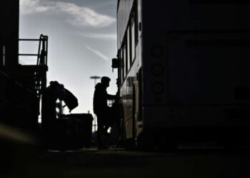 Silhouetted figures board a transport vehicle linked to Britain’s former Rwanda migrant relocation scheme