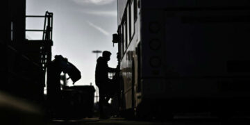 Silhouetted figures board a transport vehicle linked to Britain’s former Rwanda migrant relocation scheme