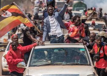 Supporters of Ugandan opposition leader Bobi Wine celebrate at a campaign rally, waving national flags as the election approaches.