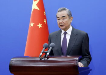 Chinese Foreign Minister Wang Yi speaks at a podium in Beijing, with the Chinese flag behind him, ahead of his official Africa tour focused on trade corridors and ports.