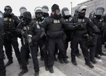 ICE officers in riot gear stand in formation during a US immigration enforcement operation