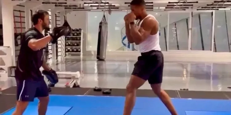 Anthony Joshua trains in a gym with a coach, practising pad work weeks after a fatal car crash in Nigeria
