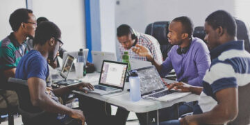 Young African software developers collaborating at a tech workspace in Zanzibar
