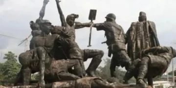 Bronze memorial statue in Enugu depicting coal miners being confronted by colonial police during the 1949 Iva Valley massacre, with one officer raising a baton above a fallen worker