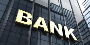 Gold BANK signage mounted on the glass façade of a modern high-rise financial buildin