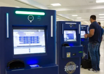 Traveller using automated biometric passport control system at airport border checkpoint