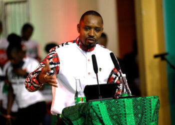Kenyan activist Boniface Mwangi speaking at a podium during a public address amid rising political tensions and surveillance allegations
