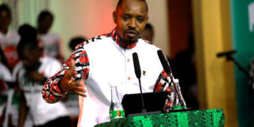Kenyan activist Boniface Mwangi speaking at a podium during a public address amid rising political tensions and surveillance allegations