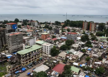 Aerial view of Conakry’s densely built administrative district near the central prison, with low-rise buildings, narrow streets and the Atlantic coast visible in the distance.