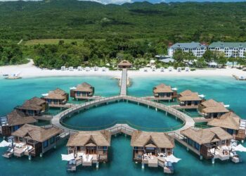 Aerial view of luxury overwater villas along Jamaica’s tropical coastline showcasing premium Caribbean tourism and resort experiences