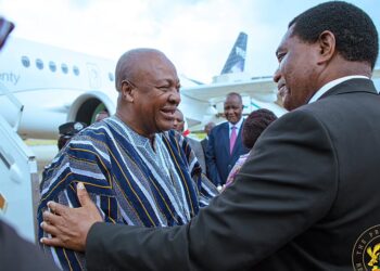Ghana’s President John Dramani Mahama wearing fugu being welcomed by Zambia’s President Hakainde Hichilema on arrival in Lusaka