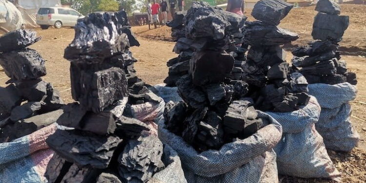 Seized bags of illegal charcoal stacked outdoors in Malawi following interception of a smuggling operation linked to a fake funeral procession
