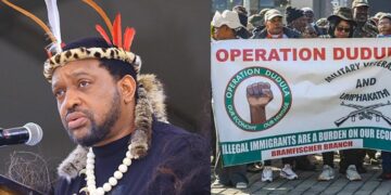 Zulu King Misuzulu speaks at a public event beside Operation Dudula supporters holding an anti-immigration banner during a protest in South Africa