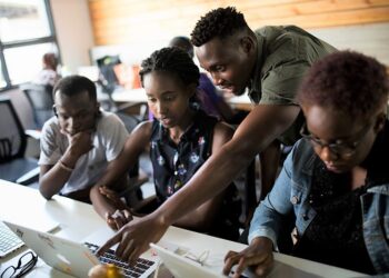 African technology professionals collaborating on laptops during AI skills development session supporting Africa’s digital transformation