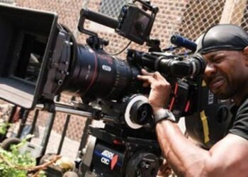 African filmmaker operating professional cinema camera during film production on set