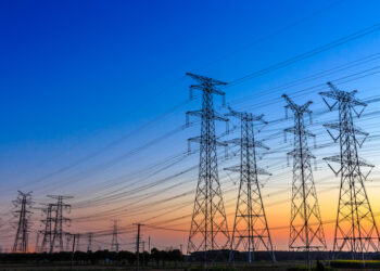 High-voltage transmission lines at sunset illustrating Malawi–Mozambique power interconnection infrastructure