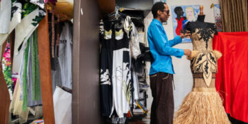 Gabonese fashion designer Chouchou Lazare adjusts a raffia dress in his Libreville studio, showcasing the traditional palm fibre used in his award-winning designs